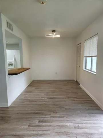 a view of empty room with wooden floor