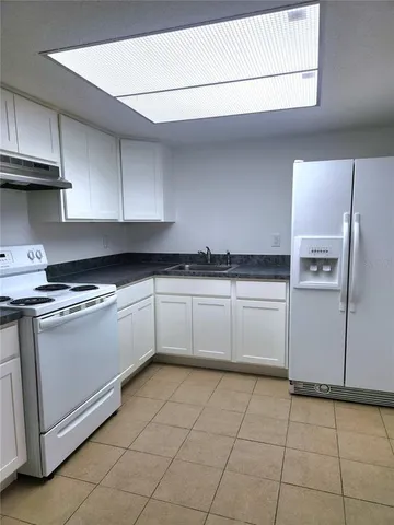 a kitchen with stainless steel appliances granite countertop a sink and a stove