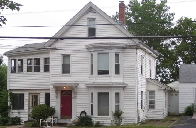 a view of house that has a small yard and large windows