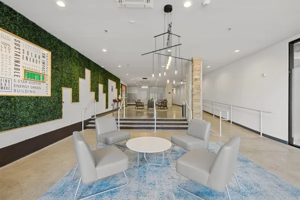 a living room with furniture a table and kitchen view