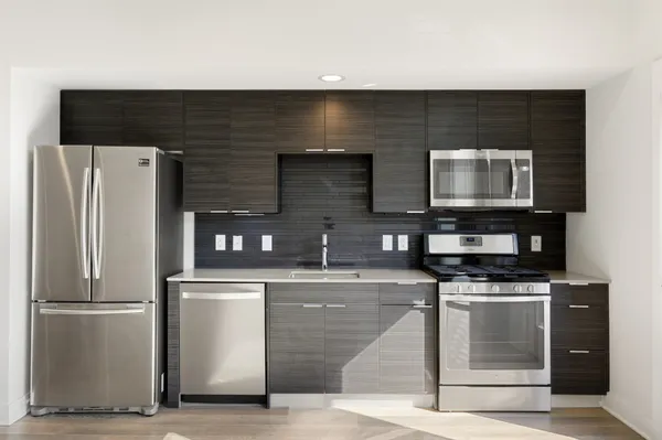 a large kitchen with a sink and stainless steel appliances