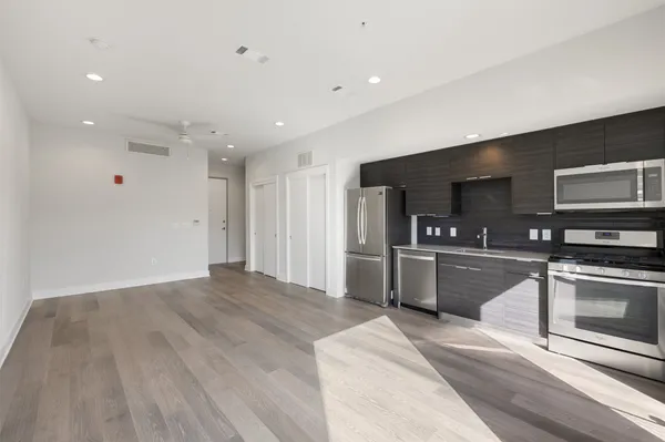 a kitchen with stainless steel appliances granite countertop a refrigerator a stove a sink and a microwave