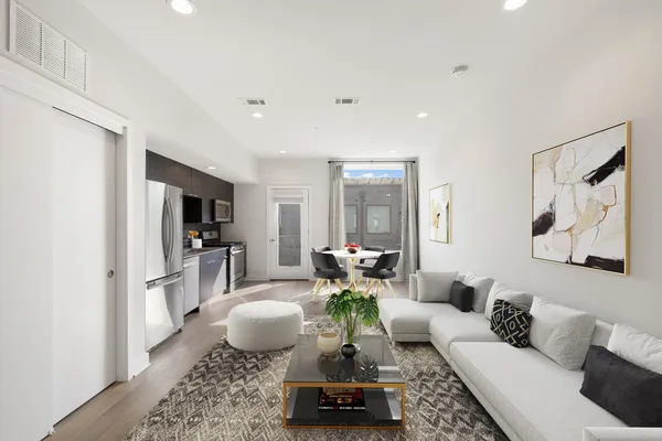 a living room with furniture a flat screen tv and a table