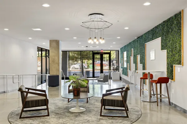 a living room with furniture a wooden floor and next to a window