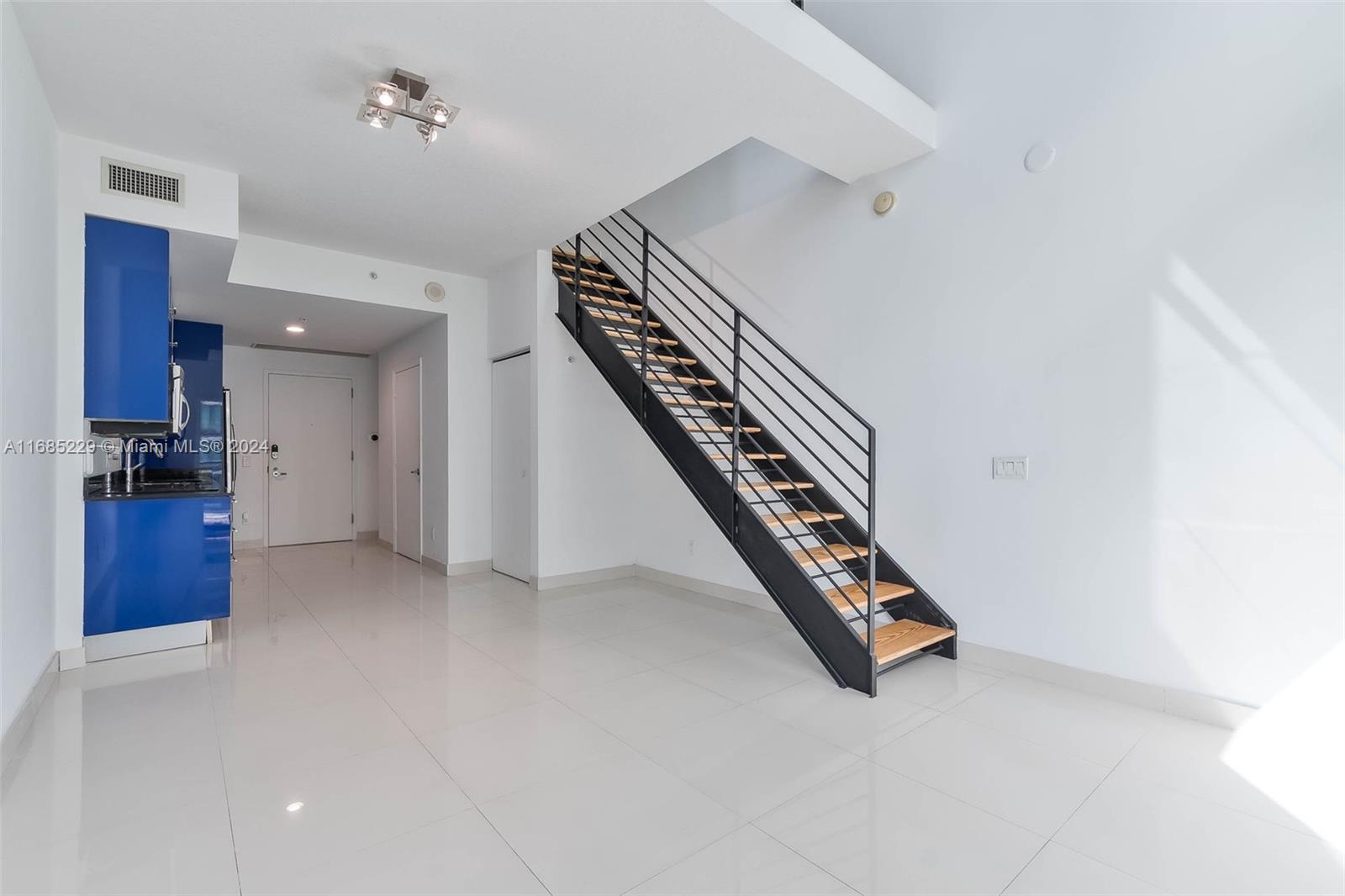 60 Southwest 13th Street, Unit 2618 Miami, FL 33130 - Photo 6 of 24 a view of an empty room with stairs and a chandelier