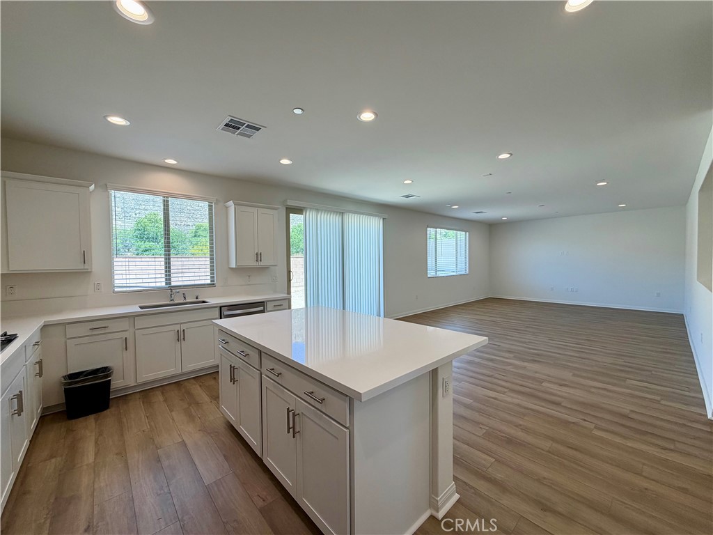 21624 Thomas Court Riverside, CA 92507 - Photo 6 of 36 a kitchen with a stove a sink a refrigerator and white cabinets with wooden floor