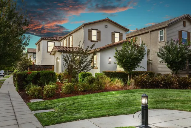 a front view of a house with a yard and a fountain