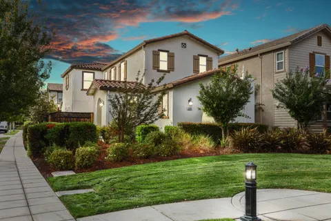 a front view of a house with a yard and a fountain