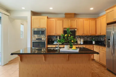 a kitchen with stainless steel appliances granite countertop sink stove and refrigerator