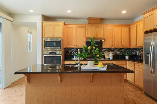 a kitchen with stainless steel appliances granite countertop sink stove and refrigerator
