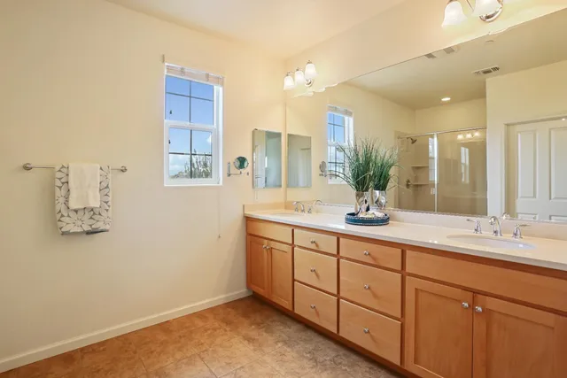 a bathroom with a double vanity sink and a mirror