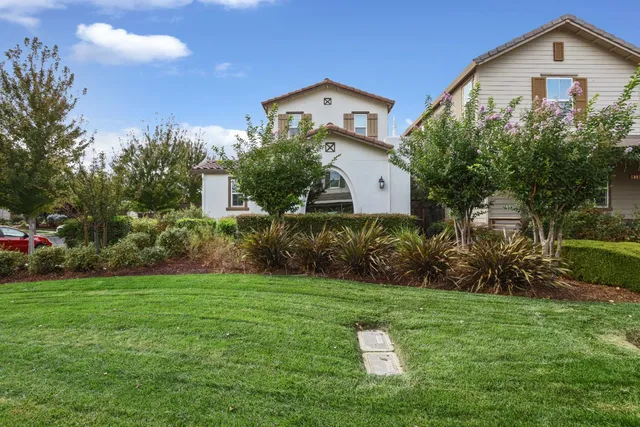 a front view of a house with a yard and trees
