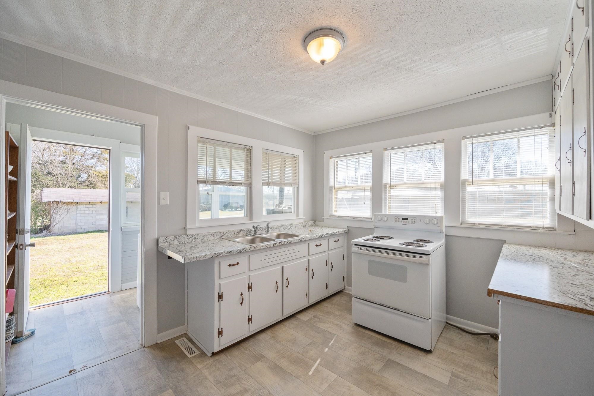 1175-1213 Perryville Road Parsons, TN 38363 - Photo 14 of 32 a kitchen with a stove a sink and a refrigerator