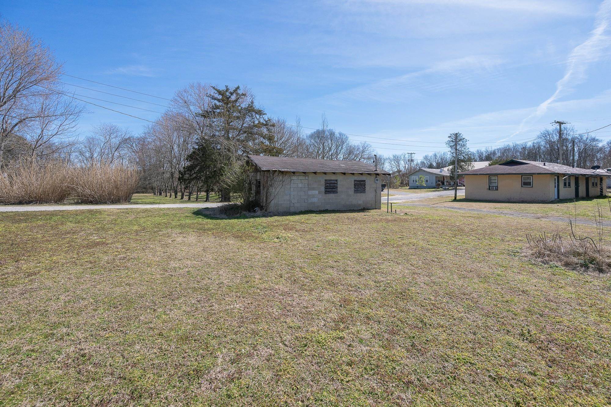 1175-1213 Perryville Road Parsons, TN 38363 - Photo 29 of 32 a view of a house with a yard and a large tree