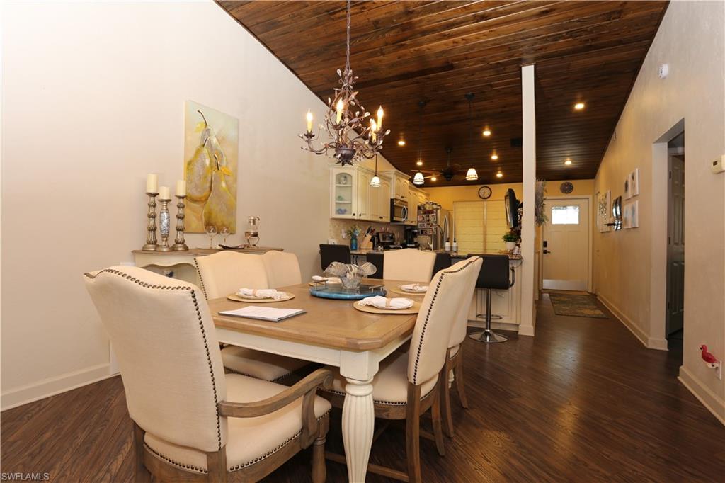 3563 Antarctic Circle, Unit 2102 Naples, FL 34112 - Photo 11 of 26 a dining room with furniture a chandelier and wooden floor