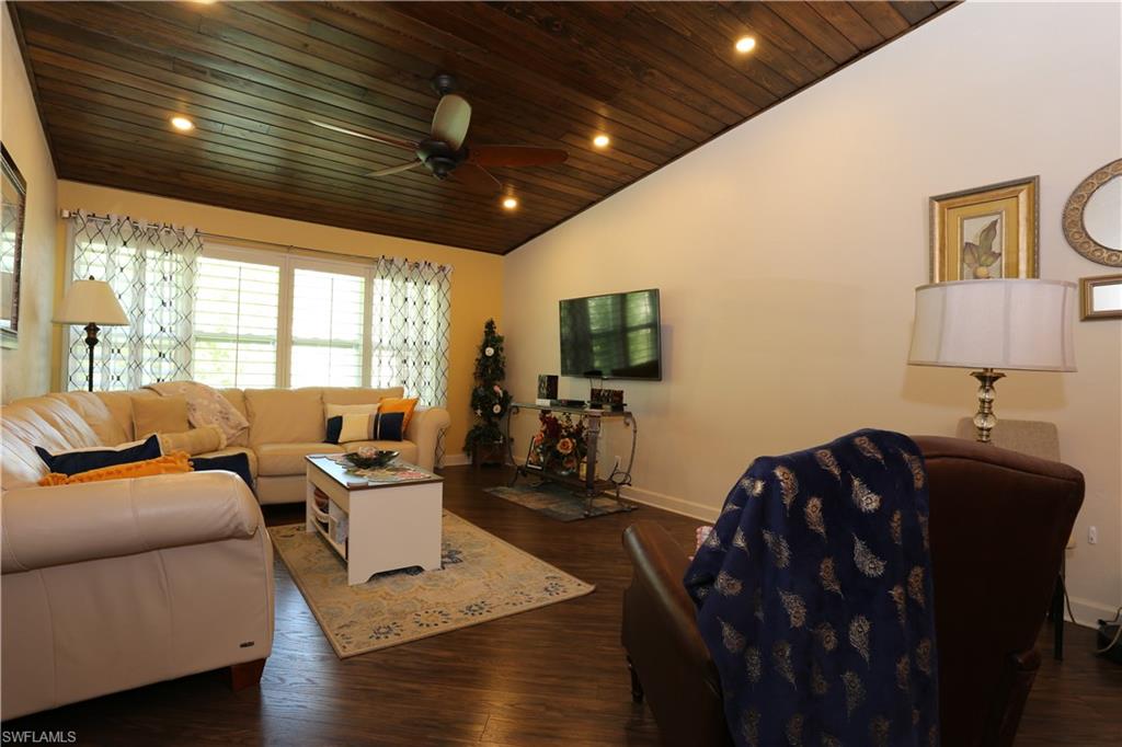 3563 Antarctic Circle, Unit 2102 Naples, FL 34112 - Photo 13 of 26 a living room with furniture a flat screen tv and a large window