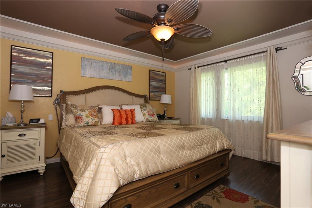 3563 Antarctic Circle, Unit 2102 Naples, FL 34112 - Photo 14 of 26 a bedroom with a bed and a chandelier