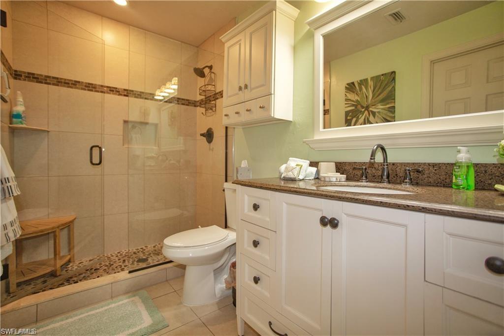 3563 Antarctic Circle, Unit 2102 Naples, FL 34112 - Photo 16 of 26 a bathroom with a granite countertop sink a toilet and shower
