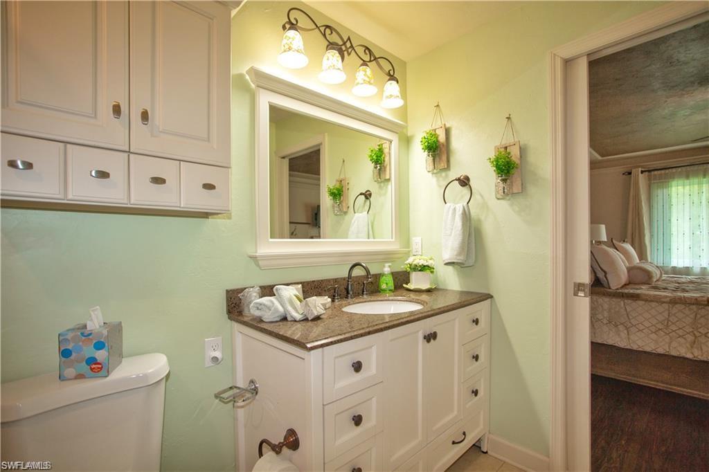 3563 Antarctic Circle, Unit 2102 Naples, FL 34112 - Photo 17 of 26 a bathroom with a sink vanity granite toilet and a mirror