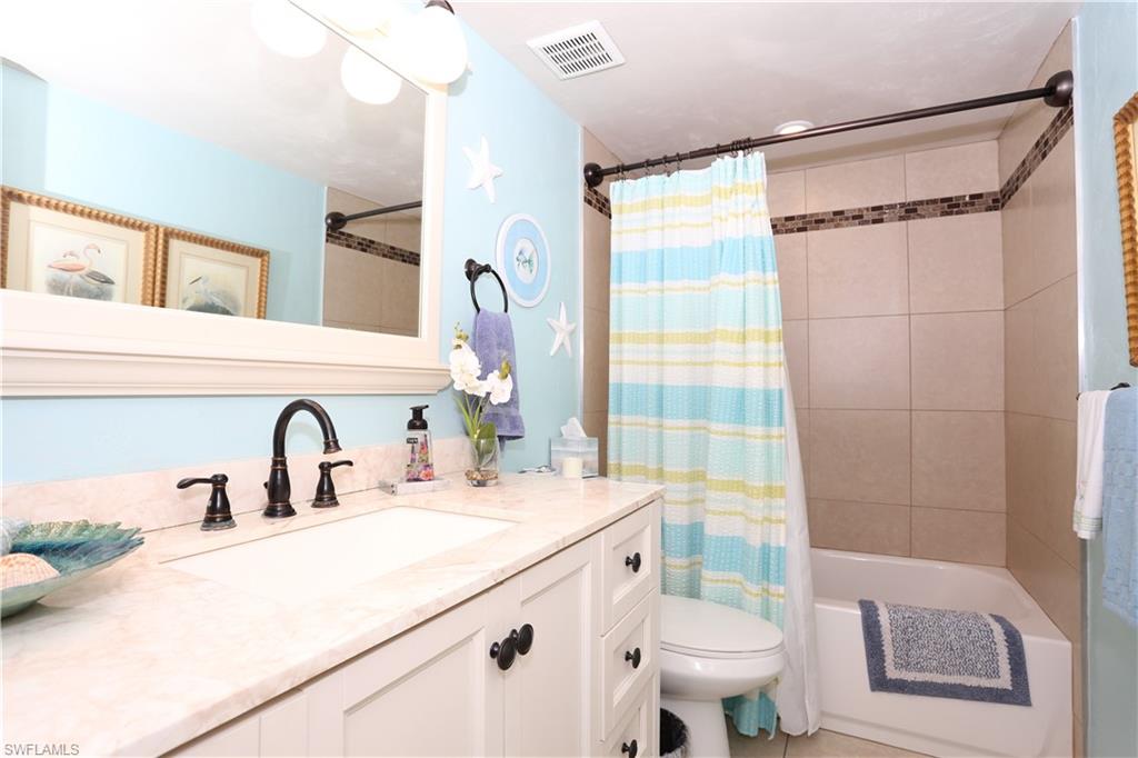 3563 Antarctic Circle, Unit 2102 Naples, FL 34112 - Photo 20 of 26 a bathroom with a sink and mirror with toilet