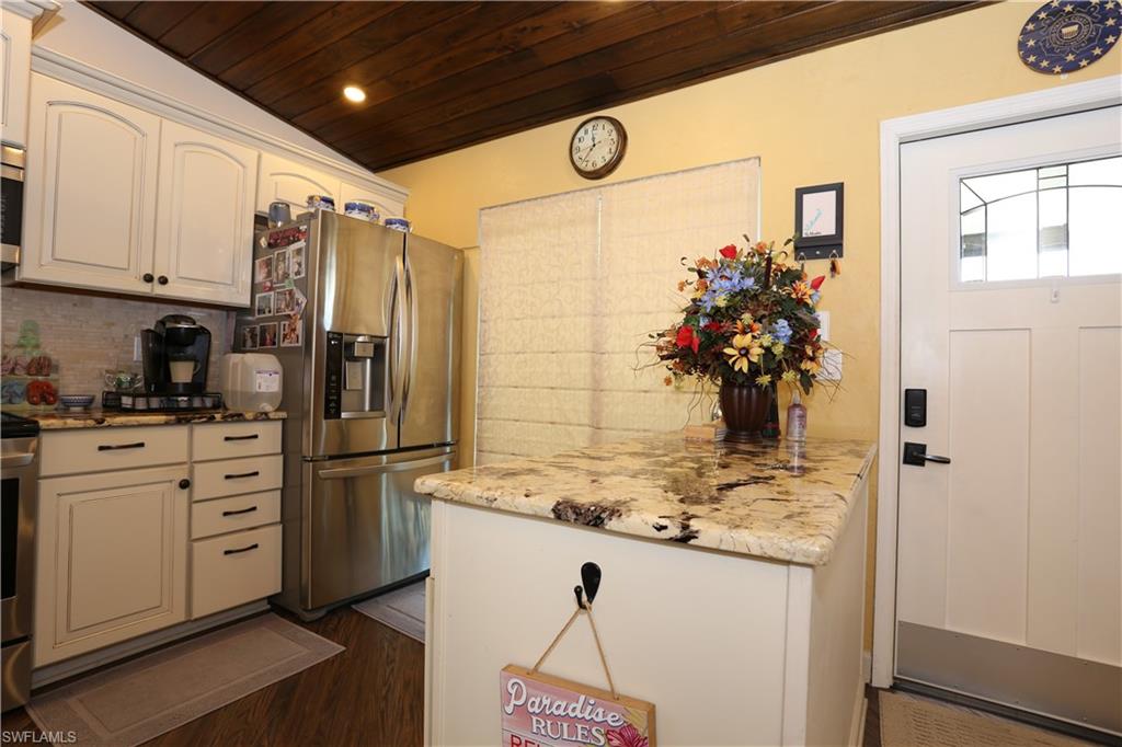 3563 Antarctic Circle, Unit 2102 Naples, FL 34112 - Photo 6 of 26 a kitchen with stainless steel appliances kitchen island granite countertop a refrigerator and microwave