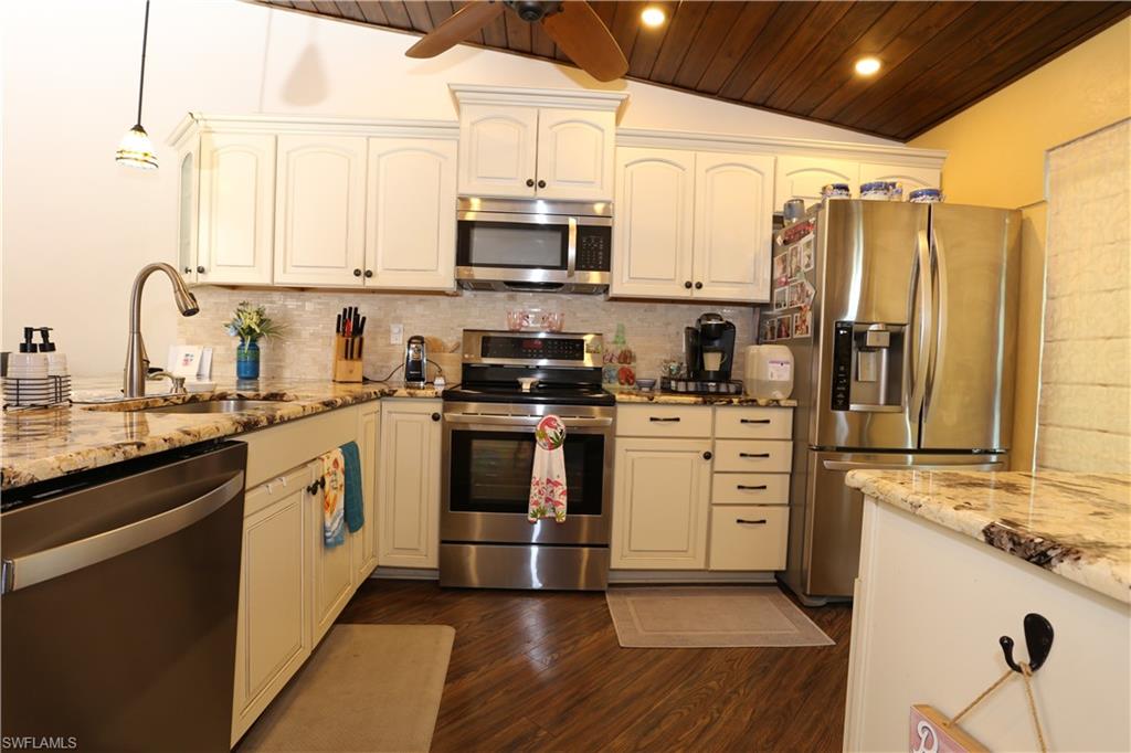 3563 Antarctic Circle, Unit 2102 Naples, FL 34112 - Photo 7 of 26 a kitchen with white cabinets and white appliances