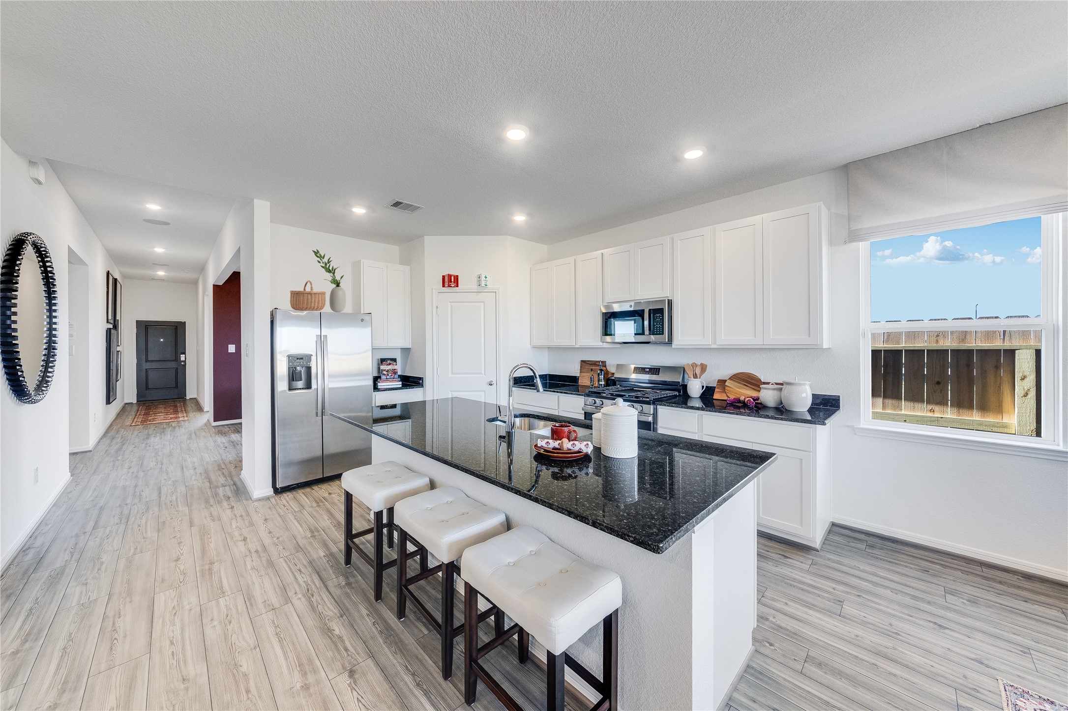 731 Willow Grove Lane Rosenberg, TX 77471 - Photo 4 of 23 a kitchen with stainless steel appliances granite countertop a refrigerator a stove top oven a sink dishwasher and white cabinets with wooden floor