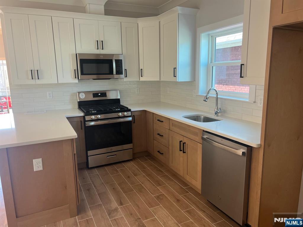 1060 Magnolia Avenue Elizabeth, NJ 07201 - Photo 14 of 22 a kitchen with a sink stove and microwave