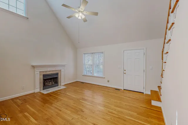 a view of empty room with wooden floor and fireplace