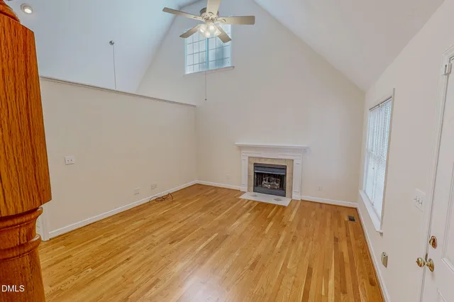 a view of empty room with wooden floor and fireplace