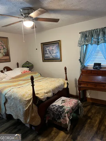 a bedroom with a bed and dresser with mirror