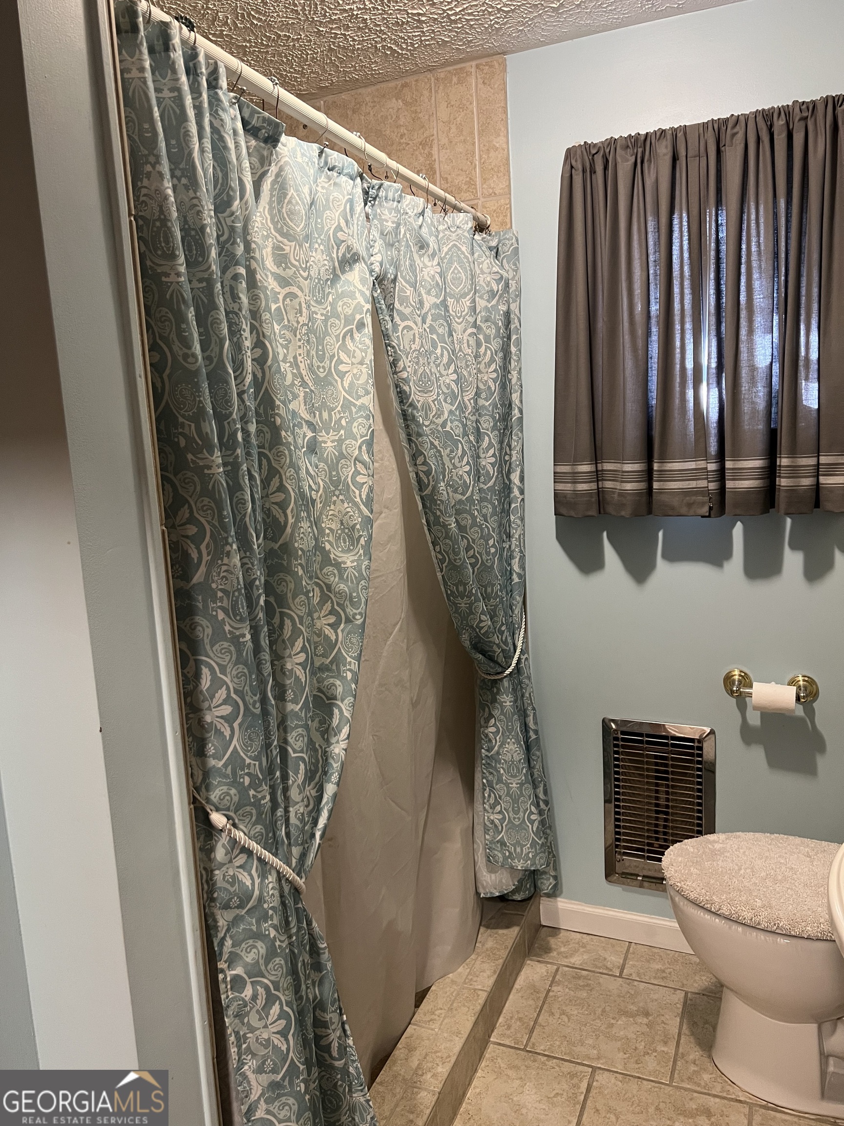 6419 Cochran Highway Cochran, GA 31014 - Photo 17 of 55 a bathroom with a toilet and a shower curtain
