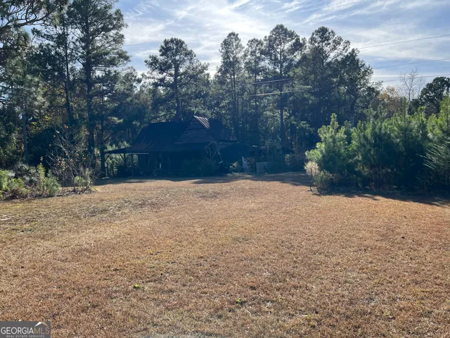 a view of a yard with wooden fence