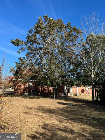 a front view of a house with a yard and trees