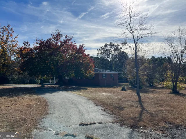 a view of backyard with wooden fence
