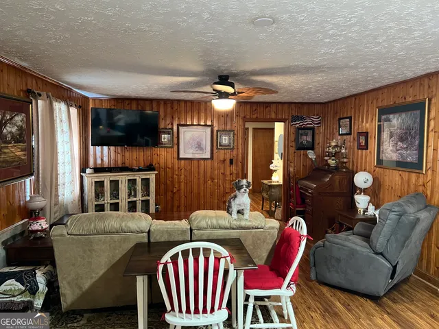 a living room with furniture a ceiling fan and a window