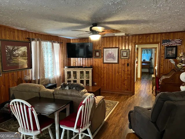 a living room with furniture a large window and a chandelier