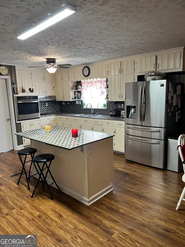 a kitchen with stainless steel appliances granite countertop a refrigerator a stove a sink dishwasher and a refrigerator