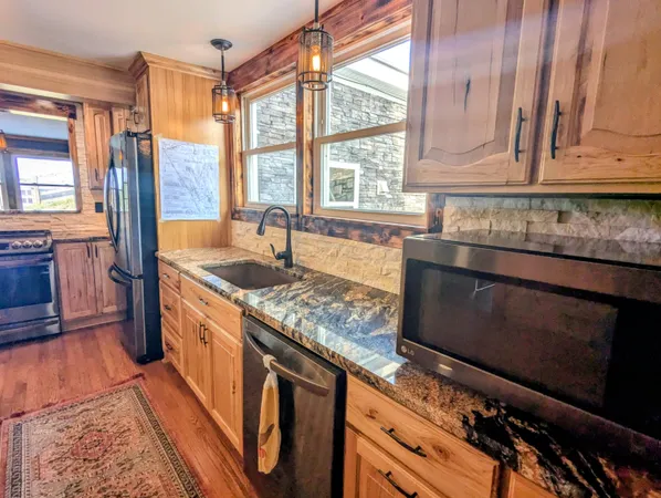 a kitchen with stainless steel appliances granite countertop a sink and cabinets