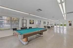 a room with pool table and windows