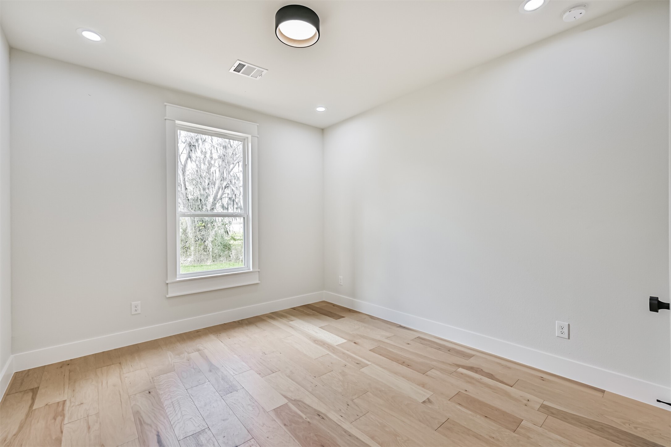 208 Pony Trail Angleton, TX 77515 - Photo 40 of 50 an empty room with wooden floor and windows
