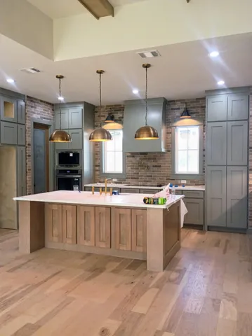 a large kitchen with kitchen island a large counter space a sink a window and stainless steel appliances