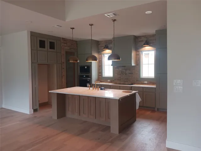 a kitchen with kitchen island a sink stove and wooden floor