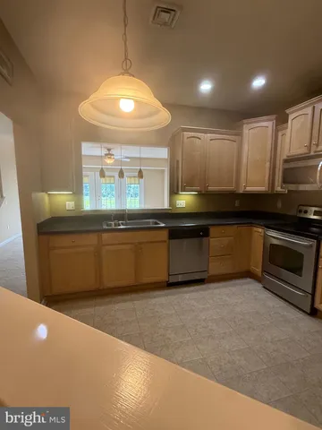 a kitchen with stainless steel appliances granite countertop a sink and a stove