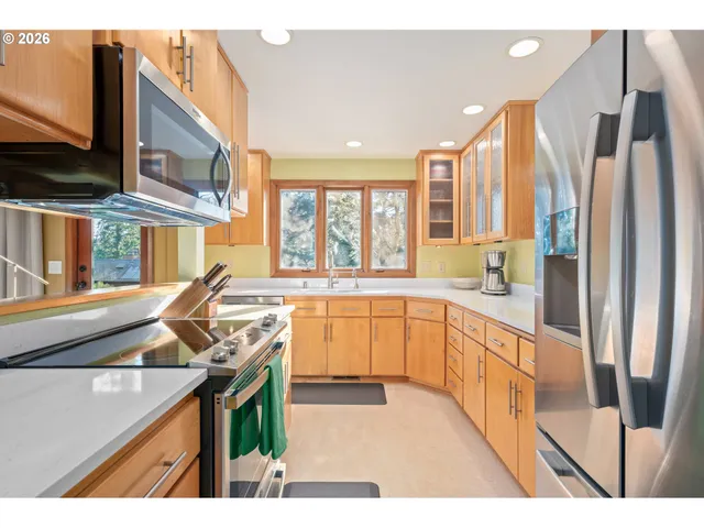 a open kitchen with stainless steel appliances granite countertop a stove a sink and a refrigerator