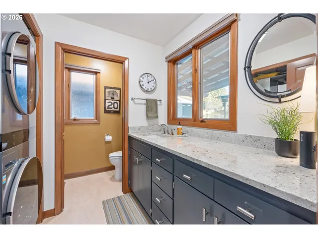 a bathroom with a granite countertop sink a mirror a vanity and a window