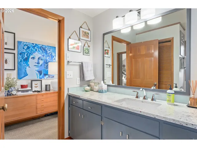 a bathroom with a granite countertop sink mirror and a shower