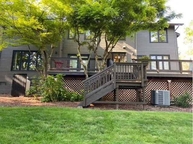 a view of a house with a wooden deck and a yard
