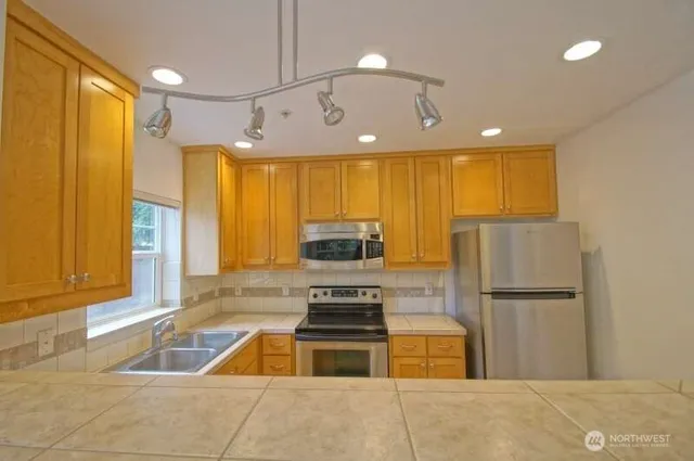 a kitchen with granite countertop a refrigerator and a sink