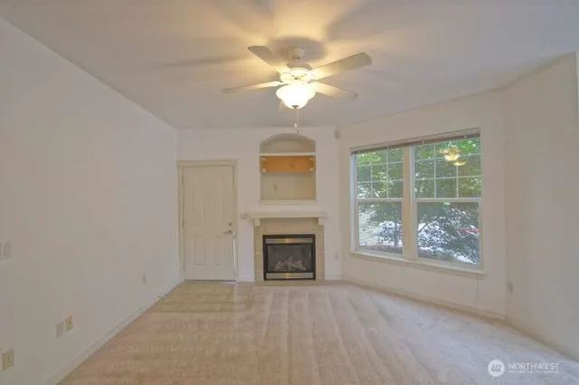 an empty room with windows and fireplace